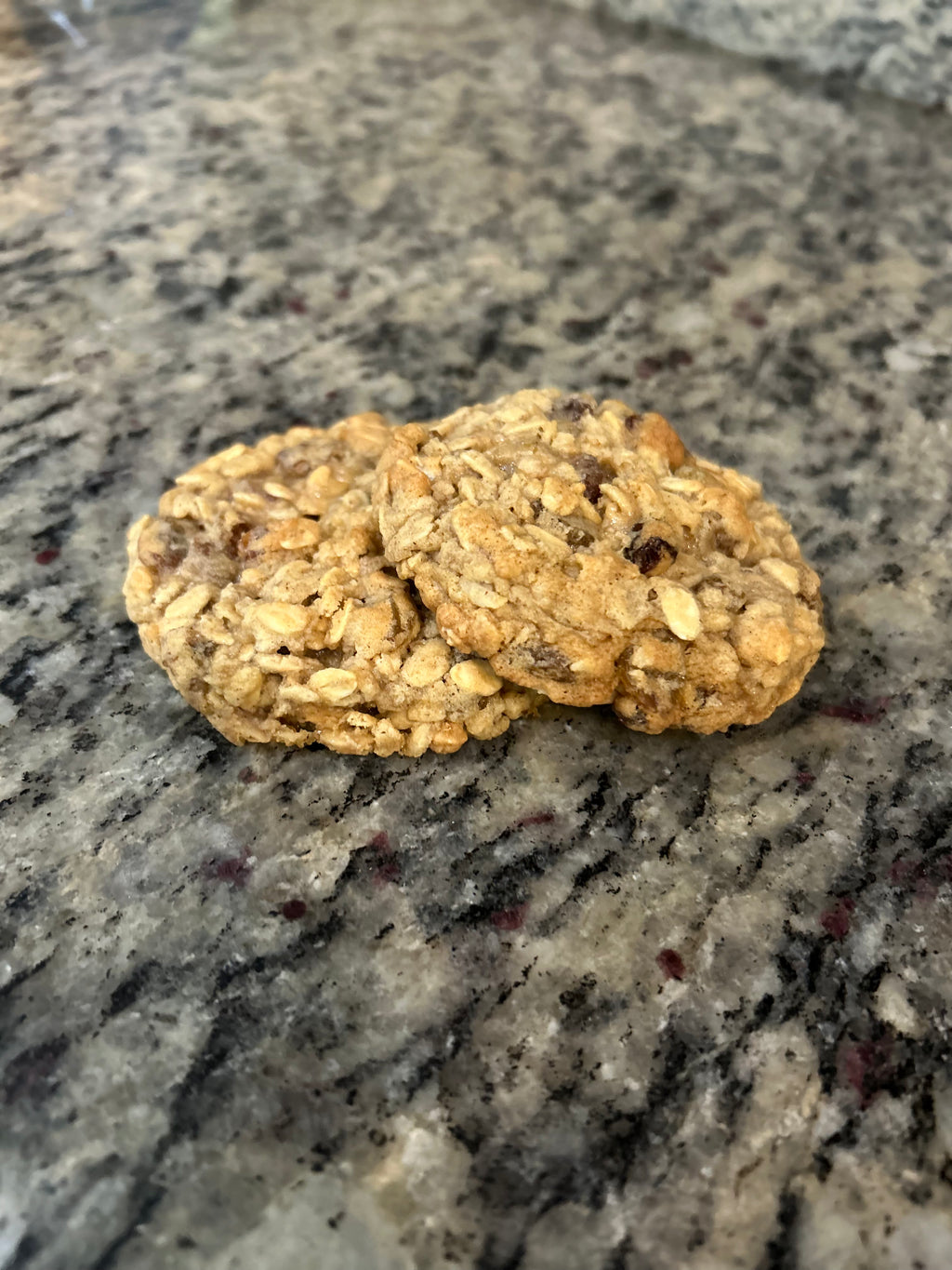 Freshly baked oatmeal cookies with golden edges on a parchment-lined tray